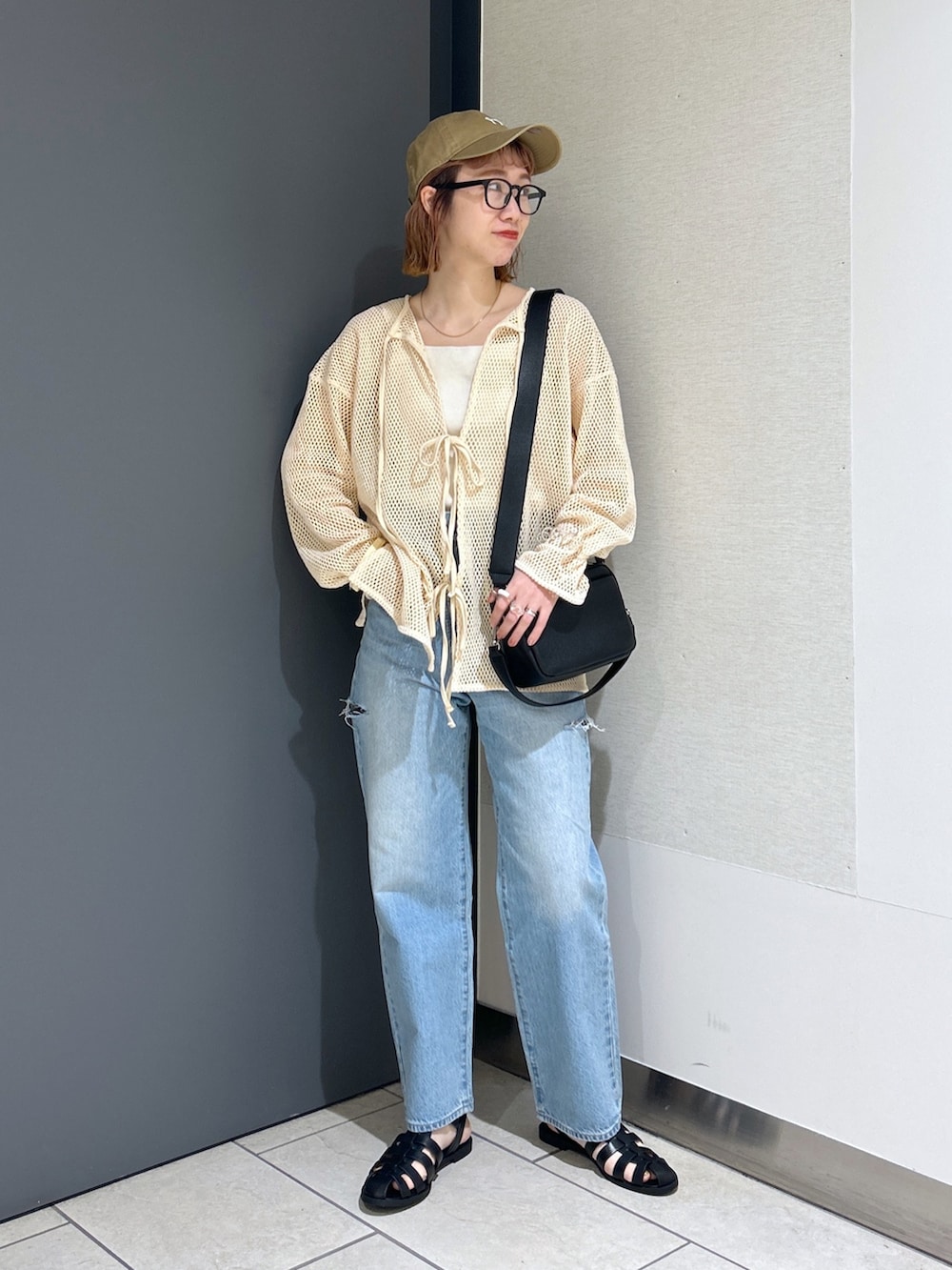 ホワイト系のタンクトップ、ホワイト系のカーディガン/ボレロ、ブラック系のショルダーバッグを着用したレディースの春コーディネートの2枚目の写真