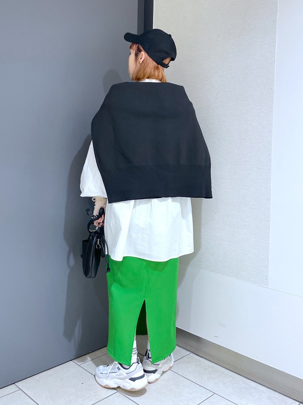 ホワイト系のスニーカー、グリーン系のスカート、ピンク系のバッグを着用したレディースの春コーディネートの3枚目の写真