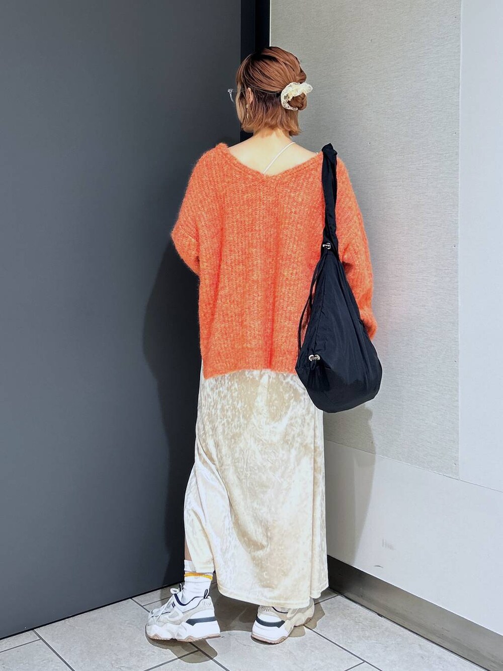 ホワイト系のタンクトップ、オレンジ系のニット/セーター、ホワイト系のスカートを着用したレディースの秋コーディネートの4枚目の写真