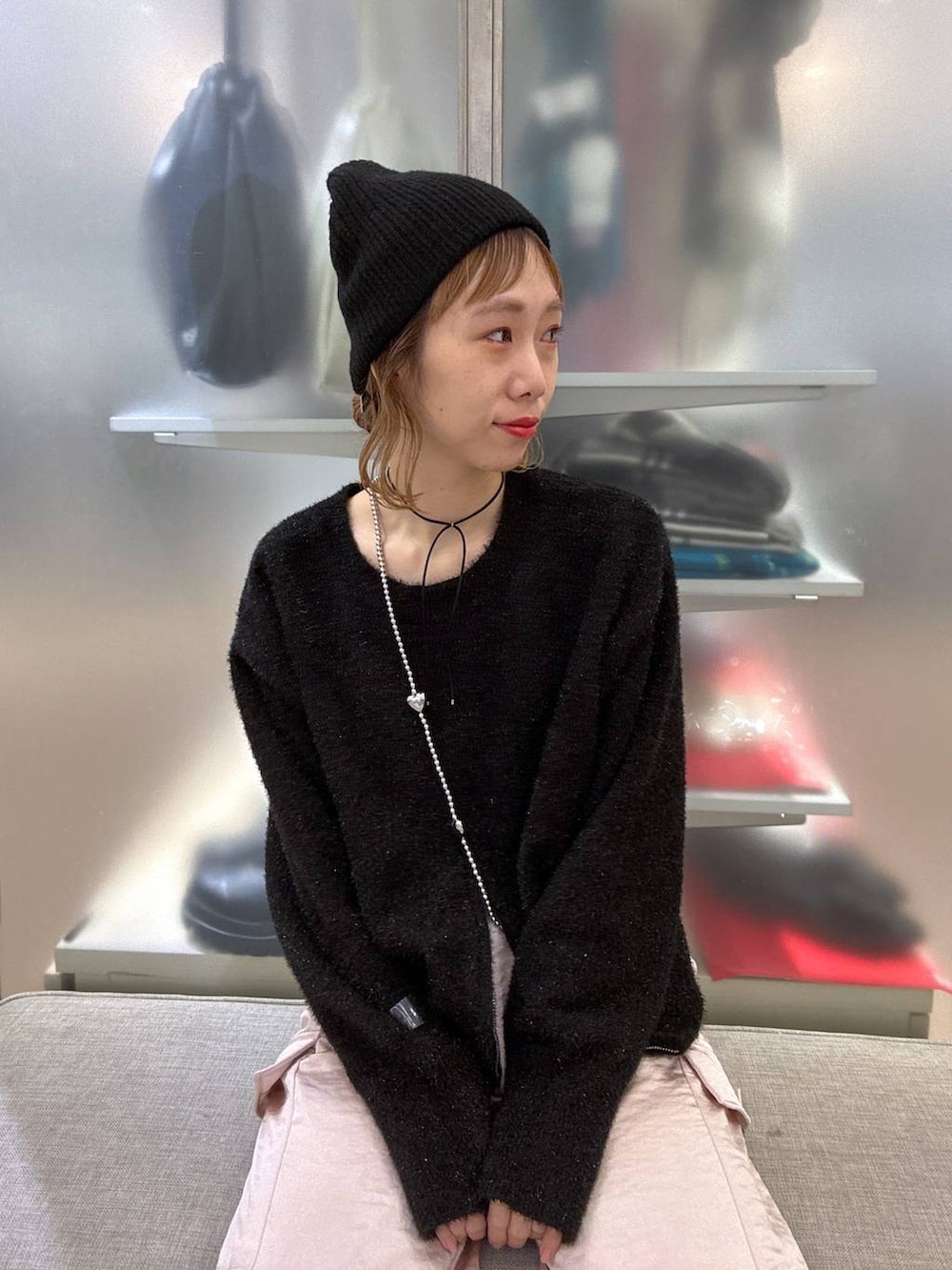 ブラック系のステンカラーコート、ピンク系のカーゴパンツ、ブラック系のニット/セーターを着用したレディースの冬コーディネートの8枚目の写真