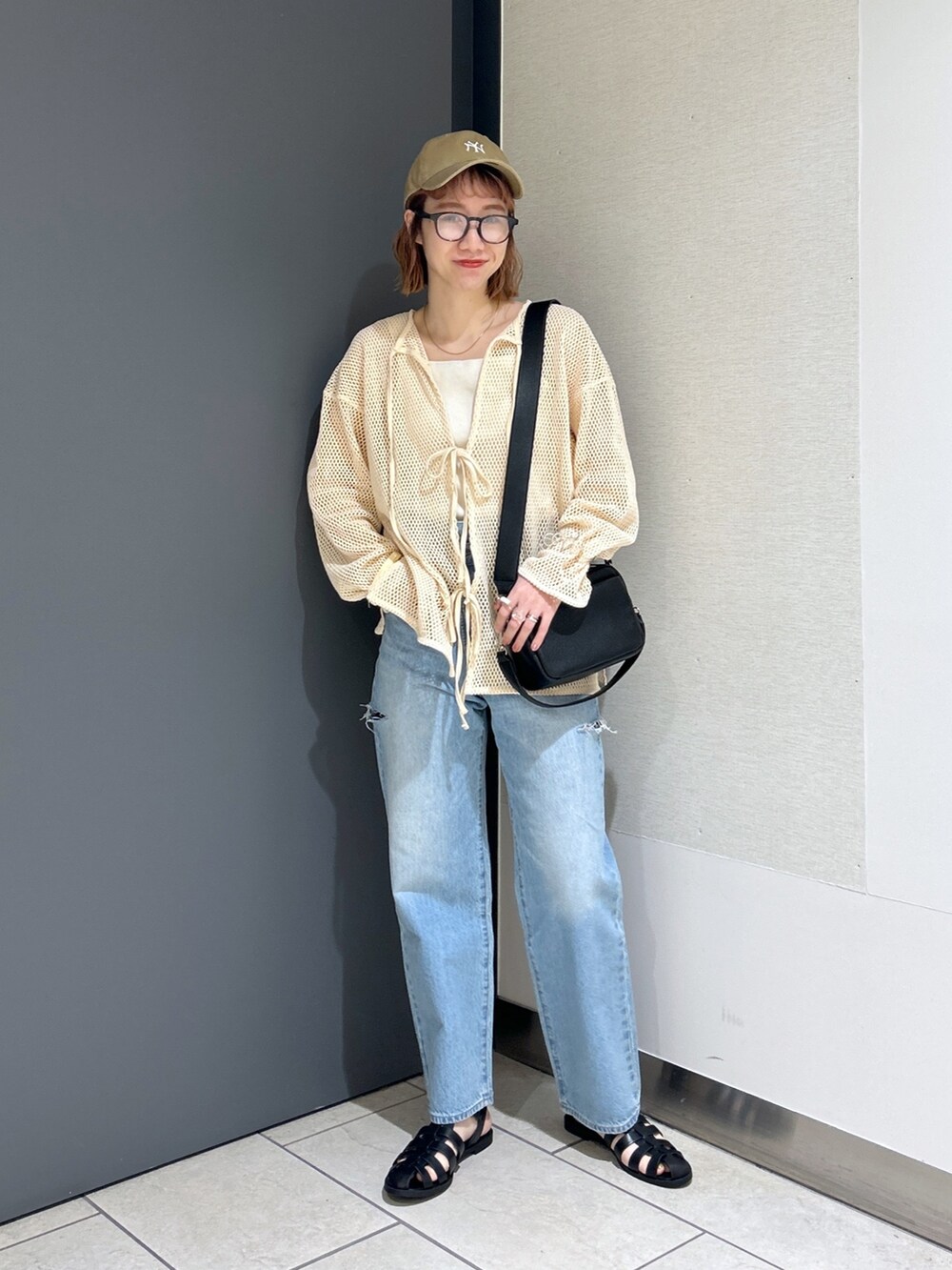 ホワイト系のタンクトップ、ホワイト系のカーディガン/ボレロ、ブラック系のショルダーバッグを着用したレディースの春コーディネートの4枚目の写真