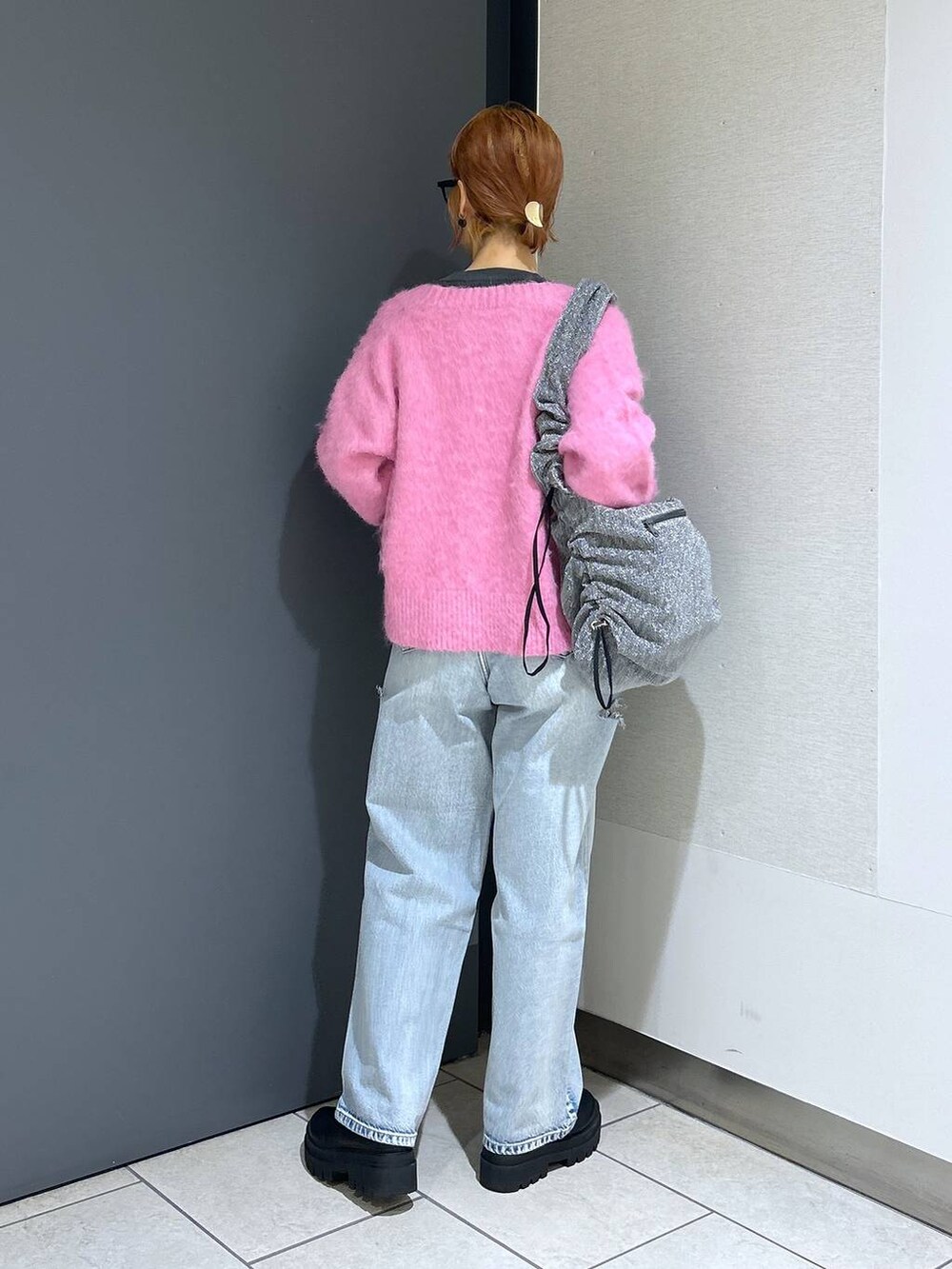 ブルー系のデニムパンツ、シルバー系のショルダーバッグ、ピンク系のカーディガン/ボレロを着用したレディースの冬コーディネートの5枚目の写真