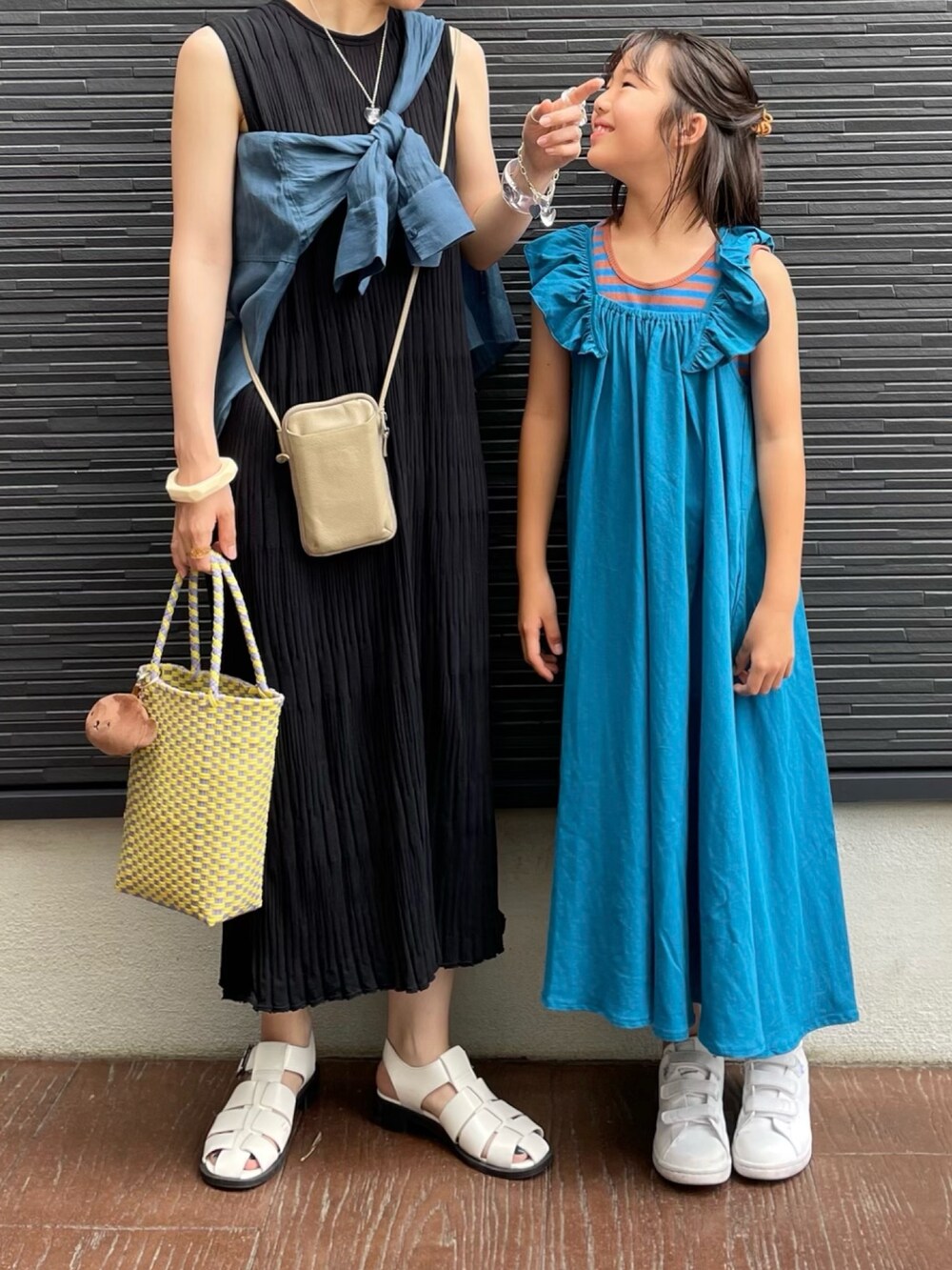 ブルー系のワンピース、ベージュ系のタンクトップ、ブラック系のワンピースを着用したレディースの夏コーディネートの2枚目の写真