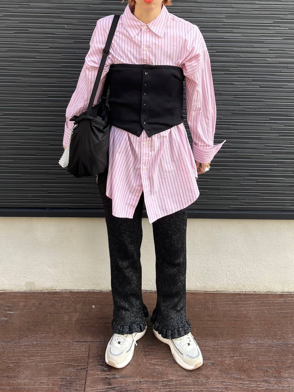 ブラック系のショルダーバッグ、ブラック系のベスト、ブラック系のその他パンツを着用したレディースの秋コーディネートの6枚目の写真