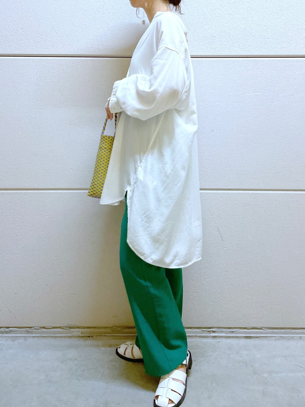 グリーン系のスラックス、パープル系のかごバッグ、ホワイト系のサンダルを着用したレディースの春コーディネートの3枚目の写真
