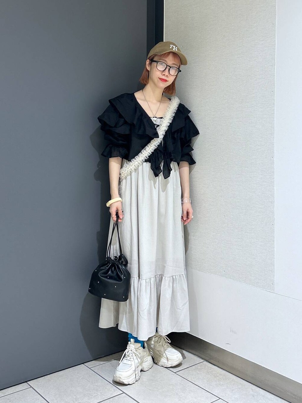 ホワイト系のワンピース、ホワイト系のスニーカー、ブラック系のショルダーバッグを着用したレディースの春コーディネートの2枚目の写真
