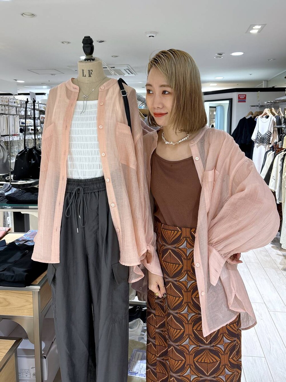 ホワイト系のトートバッグ、ブラウン系のTシャツ/カットソー、ピンク系のシャツ/ブラウスを着用したレディースの夏コーディネートの9枚目の写真