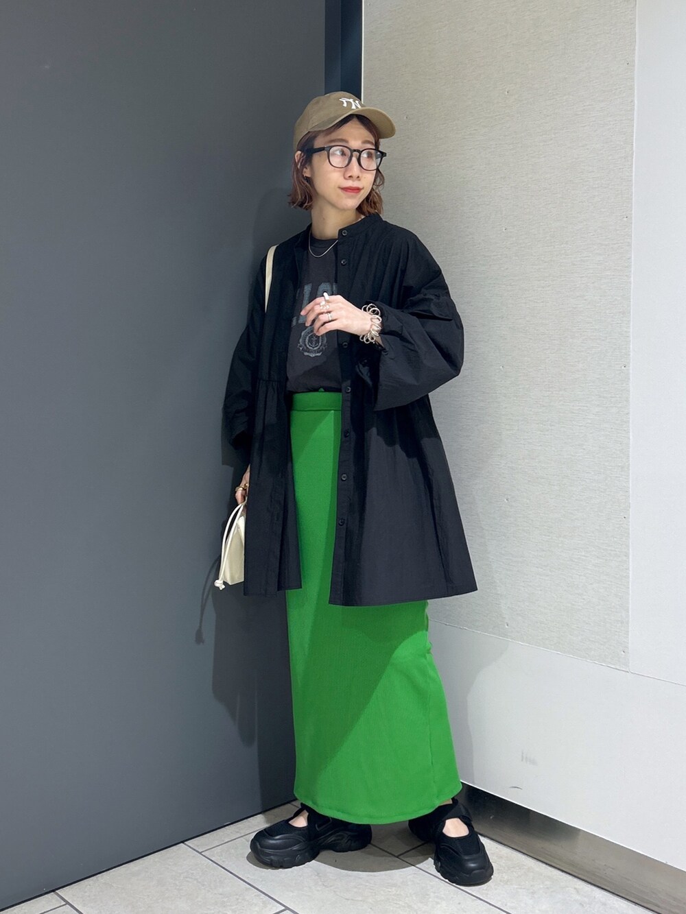 ブラック系のバッグ、グリーン系のスカート、グレー系のTシャツ/カットソーを着用したレディースの春コーディネートの7枚目の写真