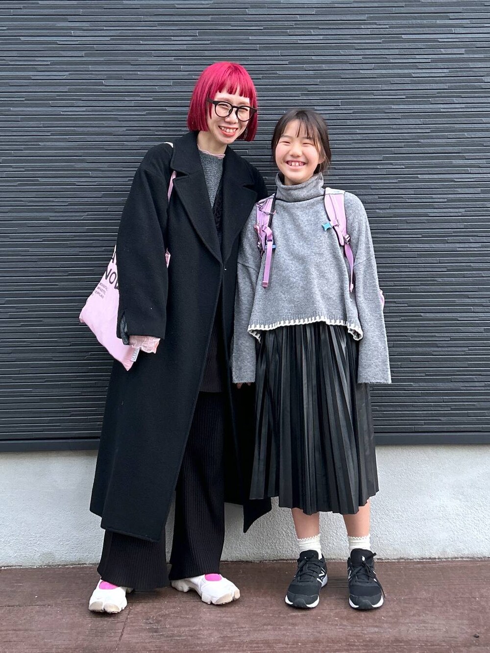 ピンク系のTシャツ/カットソー、グレー系のニット/セーター、ブラック系のスカートを着用したレディースの冬コーディネートの9枚目の写真