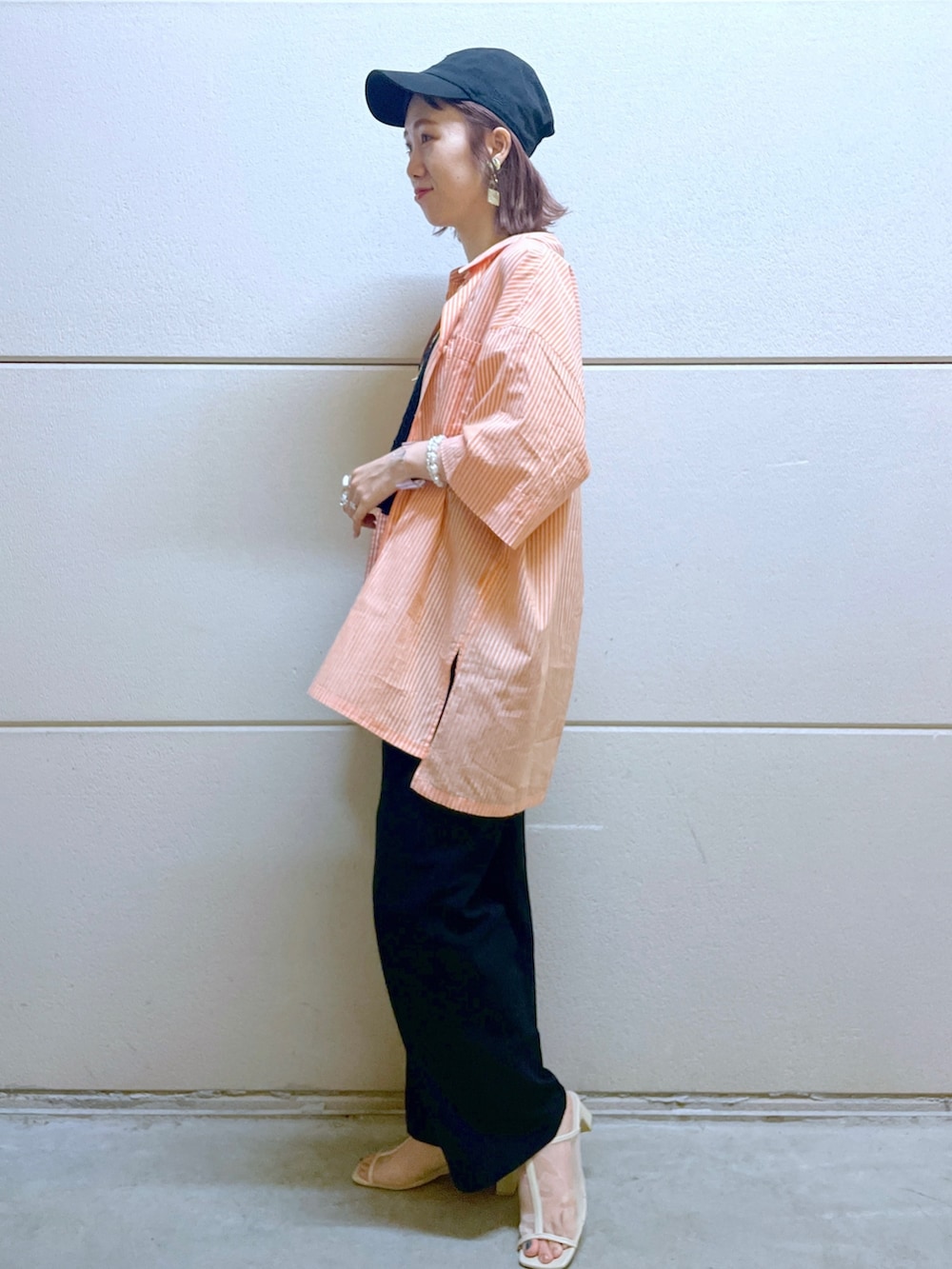 オレンジ系のシャツ/ブラウス、ブラック系のTシャツ/カットソー、ブラック系のベストを着用したレディースの春コーディネートの2枚目の写真