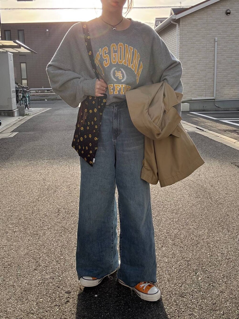 ブラウン系のトレンチコート、ブルー系のデニムパンツ、その他のネックレスを着用したレディースの春コーディネートの5枚目の写真