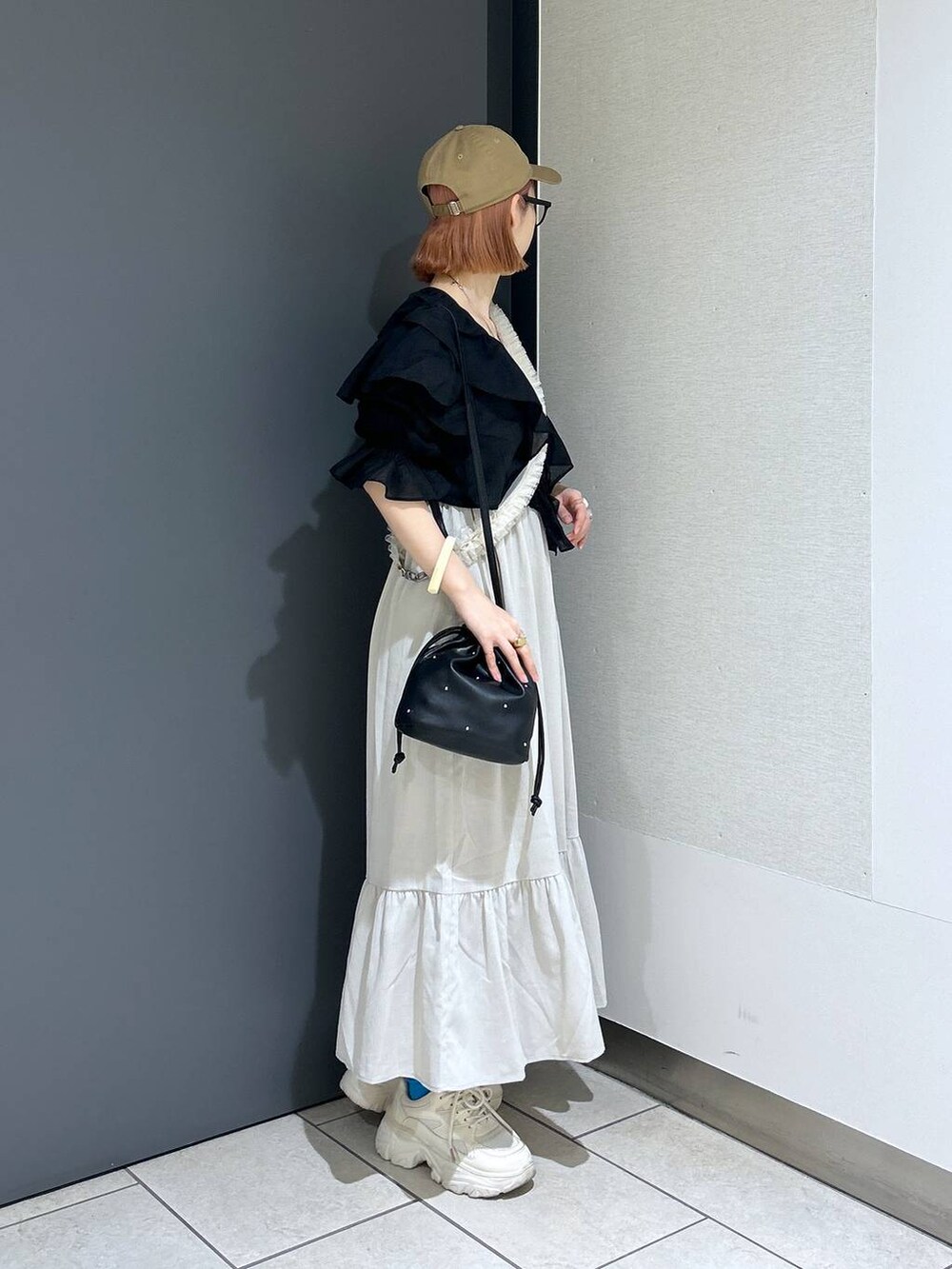 ホワイト系のワンピース、ホワイト系のスニーカー、ブラック系のショルダーバッグを着用したレディースの春コーディネートの5枚目の写真