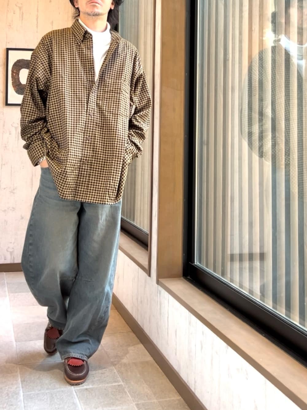 レッド系のモカシン/デッキシューズ、ブルー系のデニムパンツ、ブラック系のブルゾンを着用したメンズの冬コーディネートの2枚目の写真