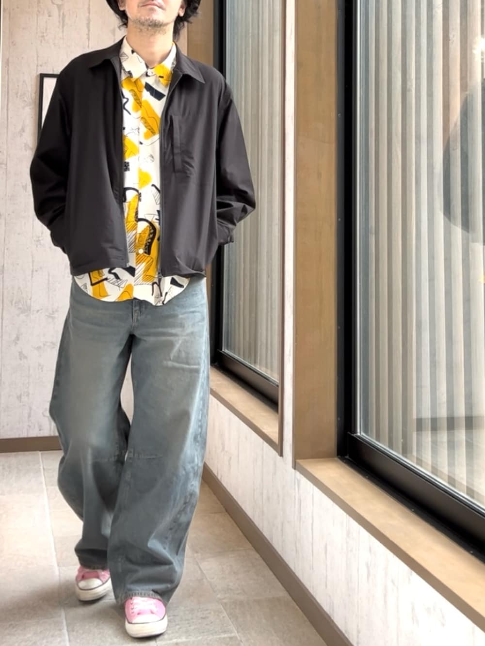 ピンク系のスニーカー、ブルー系のデニムパンツ、ブラック系のジャケット/アウターを着用したメンズの秋コーディネートの2枚目の写真