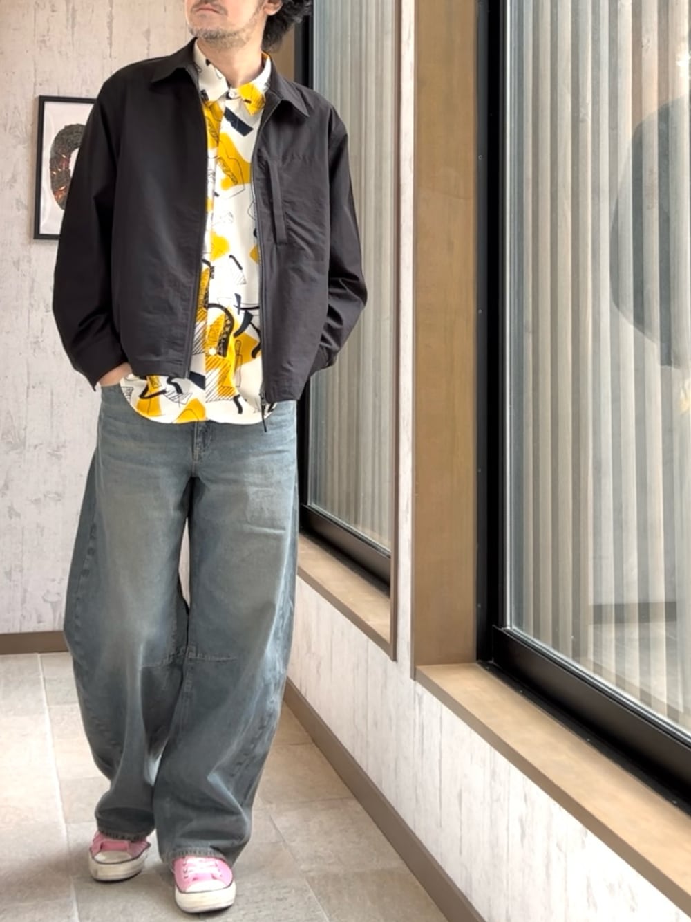 ピンク系のスニーカー、ブルー系のデニムパンツ、ブラック系のジャケット/アウターを着用したメンズの秋コーディネートの3枚目の写真