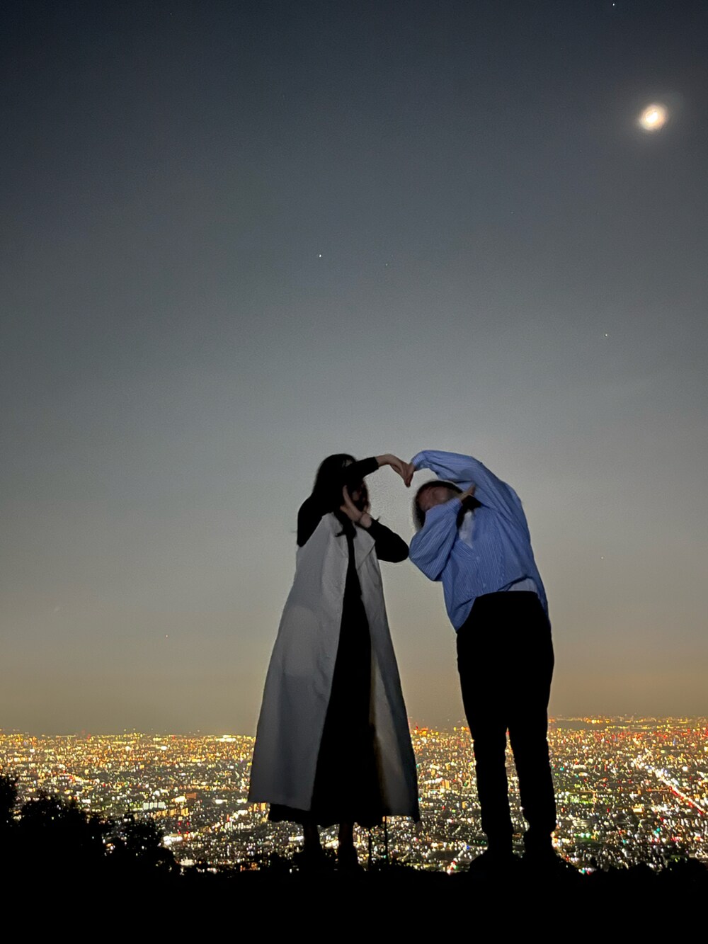 ベージュ系のトレンチコート、ブラック系のスカート、グレー系のトートバッグを着用したレディースの春コーディネートの2枚目の写真