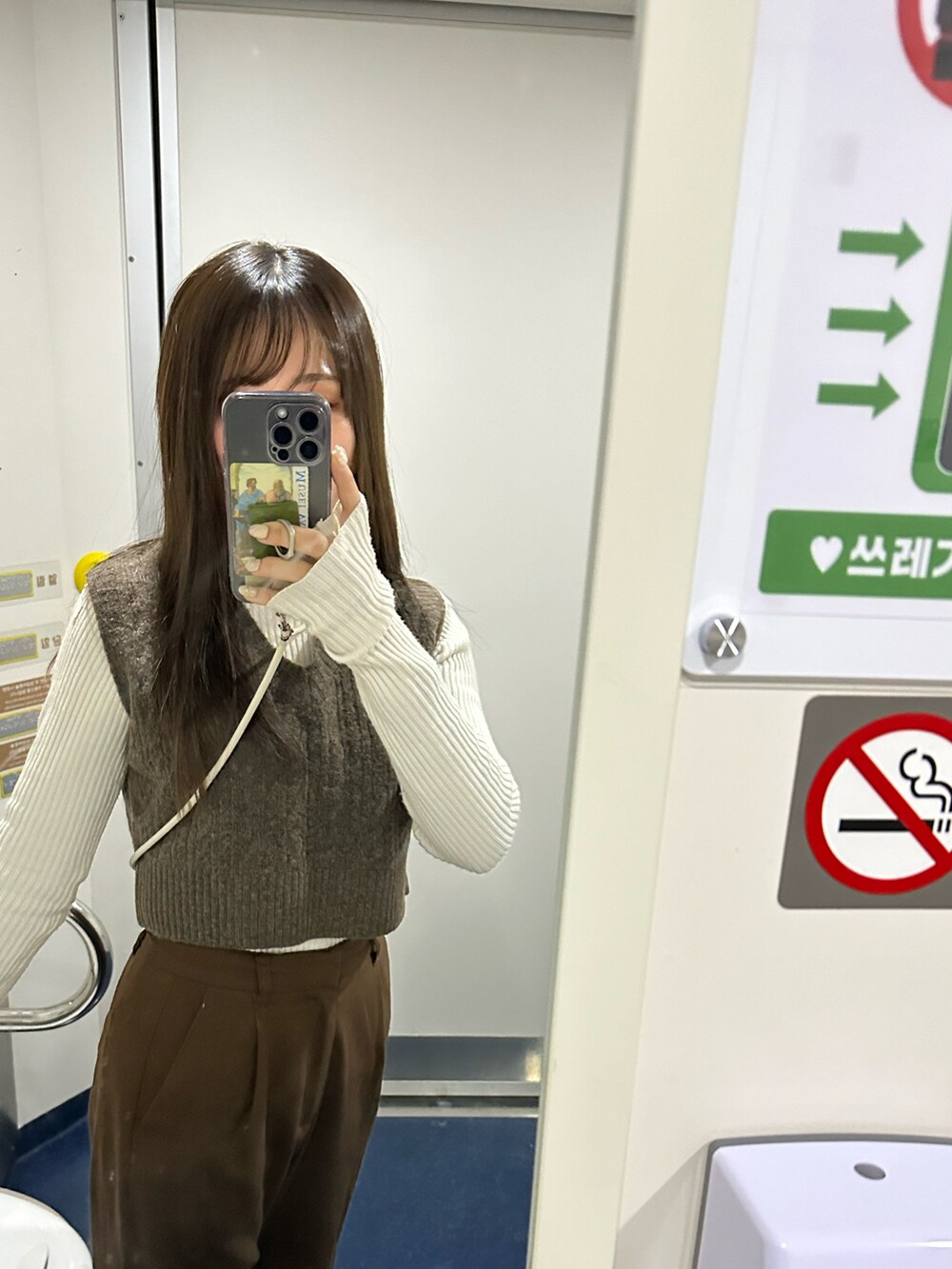 ホワイト系のステンカラーコート、ホワイト系のブーツ、グレー系の帽子を着用したレディースの冬コーディネートの3枚目の写真
