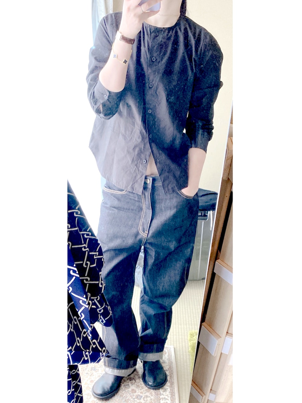 ブラック系のシャツ/ブラウス、ブルー系のデニムパンツ、ブラック系のスリッポンを着用したレディースの秋コーディネートの3枚目の写真