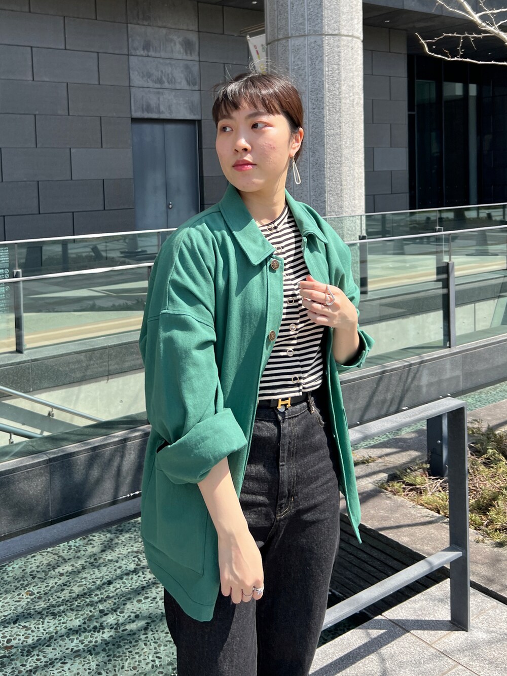 ブラック系のデニムパンツ、グリーン系のその他アウターを着用したレディースの春コーディネートの4枚目の写真