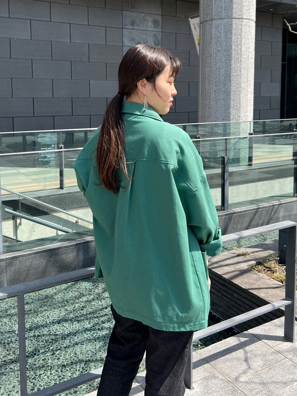 ブラック系のデニムパンツ、グリーン系のその他アウターを着用したレディースの春コーディネートの5枚目の写真