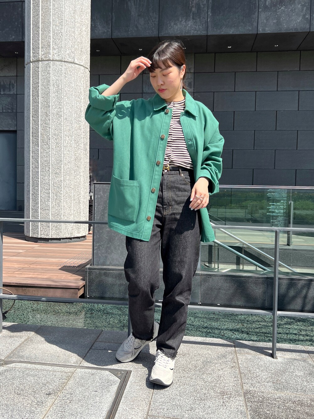 ブラック系のデニムパンツ、グリーン系のその他アウターを着用したレディースの春コーディネートの3枚目の写真