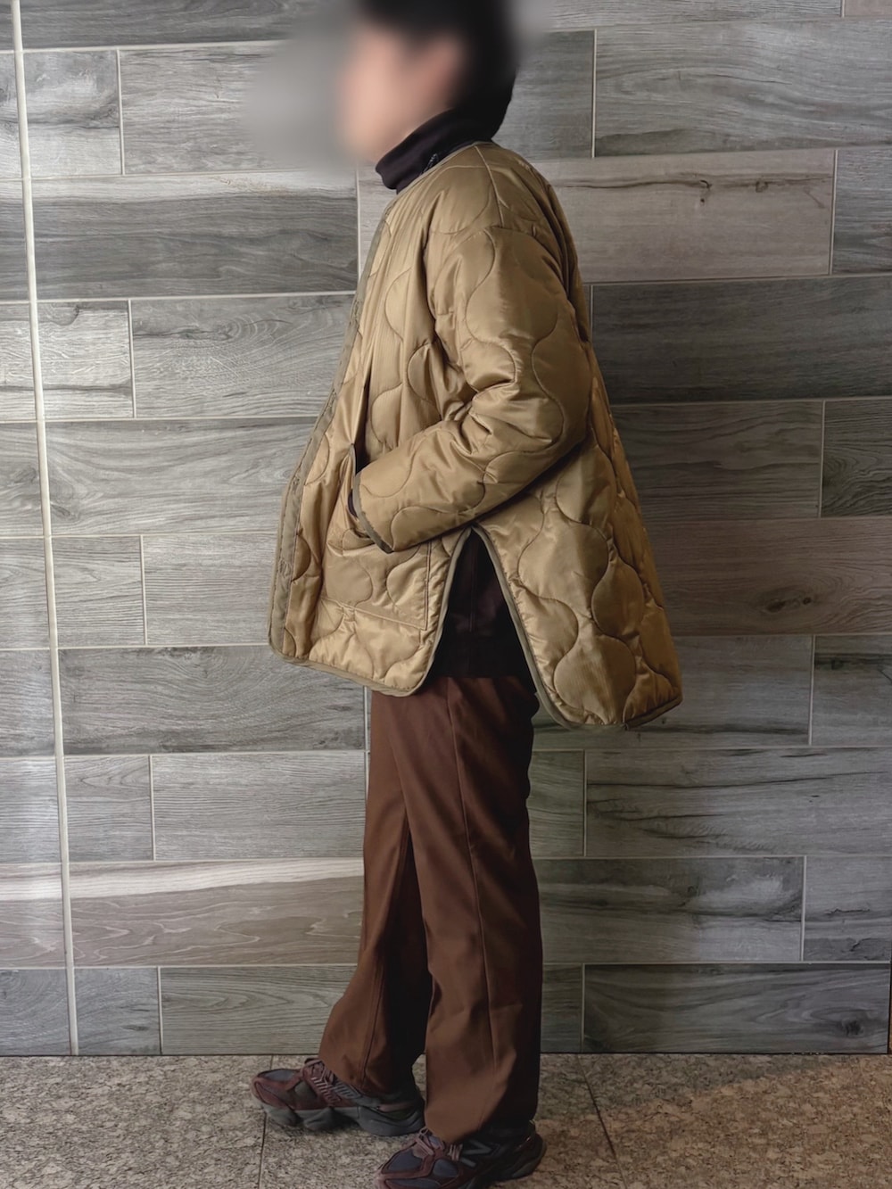 グリーン系のミリタリージャケット、ブラウン系のスウェット、ブラウン系のスラックスを着用したメンズの春コーディネートの2枚目の写真