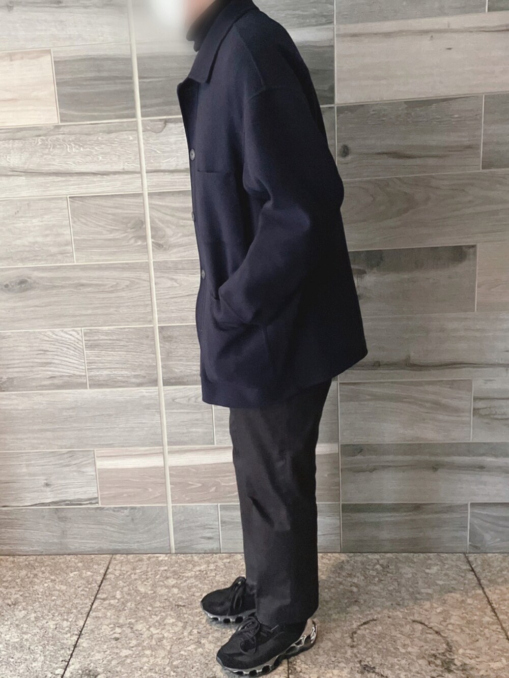 ブルー系のカバーオール、ブラック系のニット/セーター、ブラック系のスラックスを着用したメンズの冬コーディネートの2枚目の写真