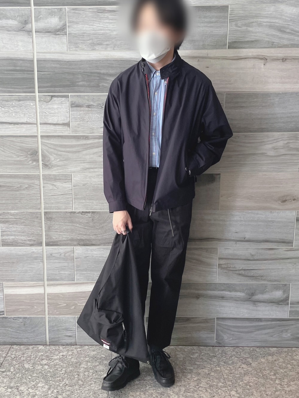 ブルー系のブルゾン、ブラック系のスラックス、ブラック系のブーツを着用したメンズの秋コーディネートの3枚目の写真