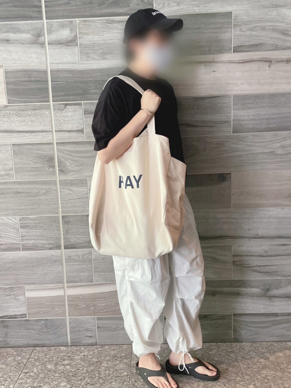 ブラック系のTシャツ/カットソー、ホワイト系のカーゴパンツ、ブラック系のサンダルを着用したメンズの夏コーディネートの2枚目の写真