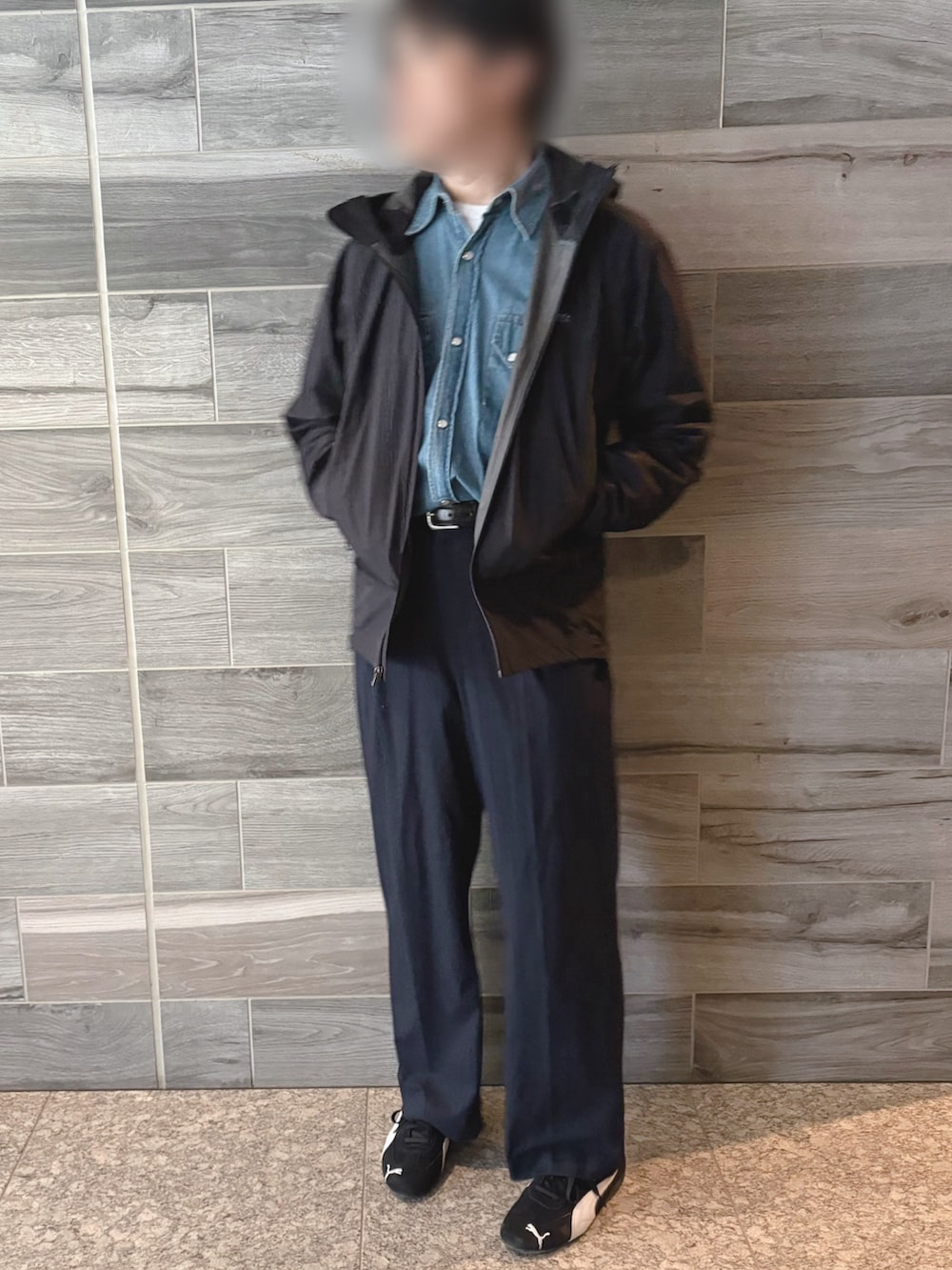 ブラック系のマウンテンパーカー、ブルー系のシャツ/ブラウス、ブルー系のスラックスを着用したメンズの冬コーディネートの2枚目の写真