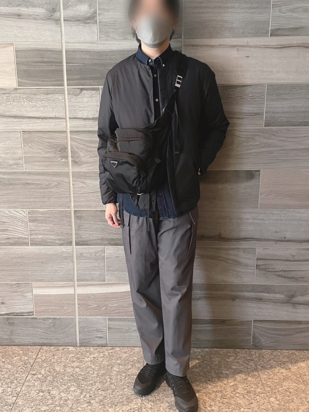 ブラック系のダウンジャケット/コート、ブルー系のシャツ/ブラウス、グレー系のパンツを着用したメンズの冬コーディネートの2枚目の写真