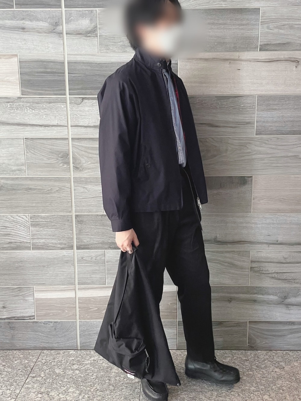 ブルー系のブルゾン、ブラック系のスラックス、ブラック系のブーツを着用したメンズの秋コーディネートの2枚目の写真