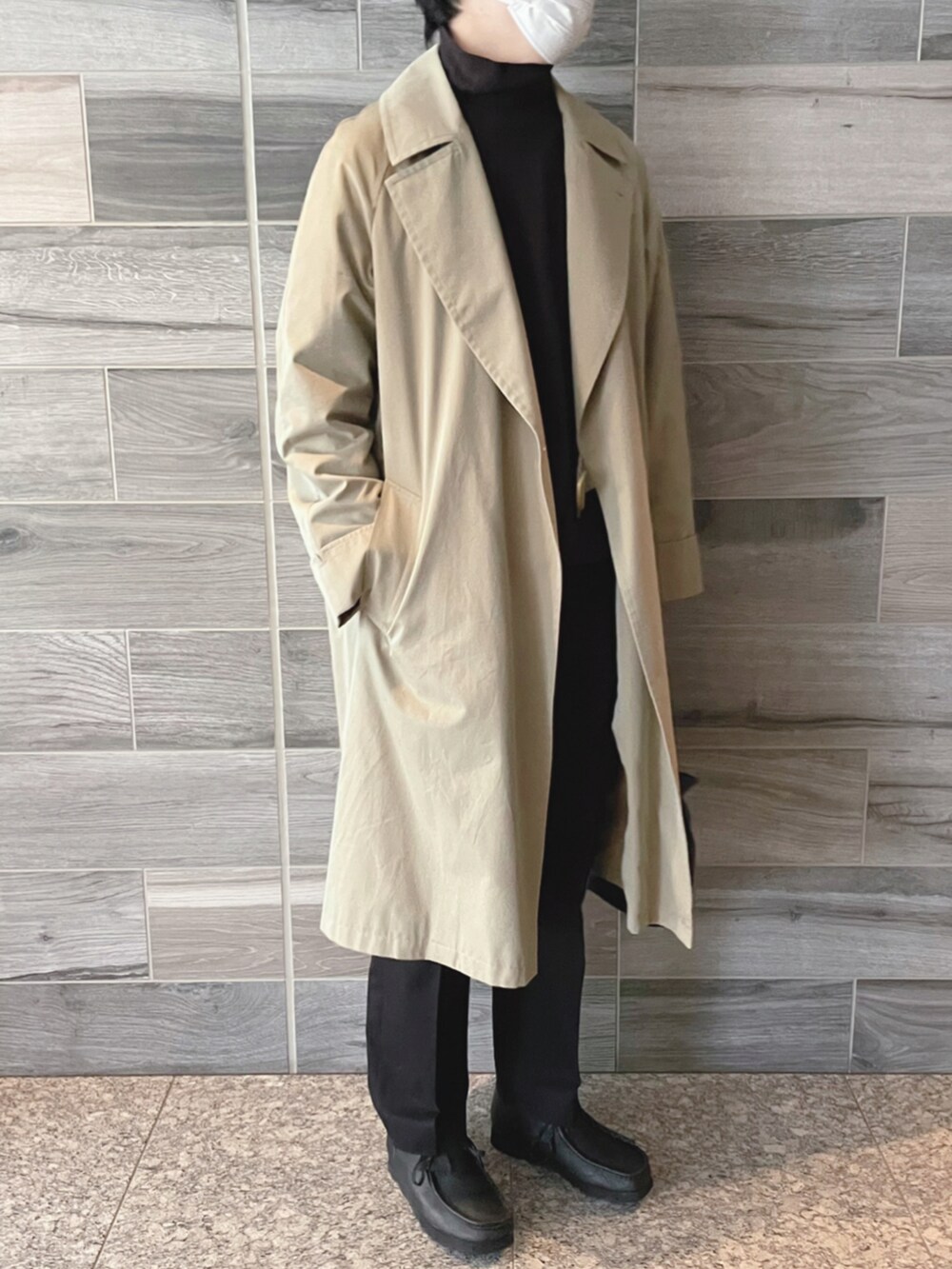 ベージュ系のトレンチコート、ブラウン系のスウェット、ブラック系のスラックスを着用したメンズの秋コーディネートの2枚目の写真