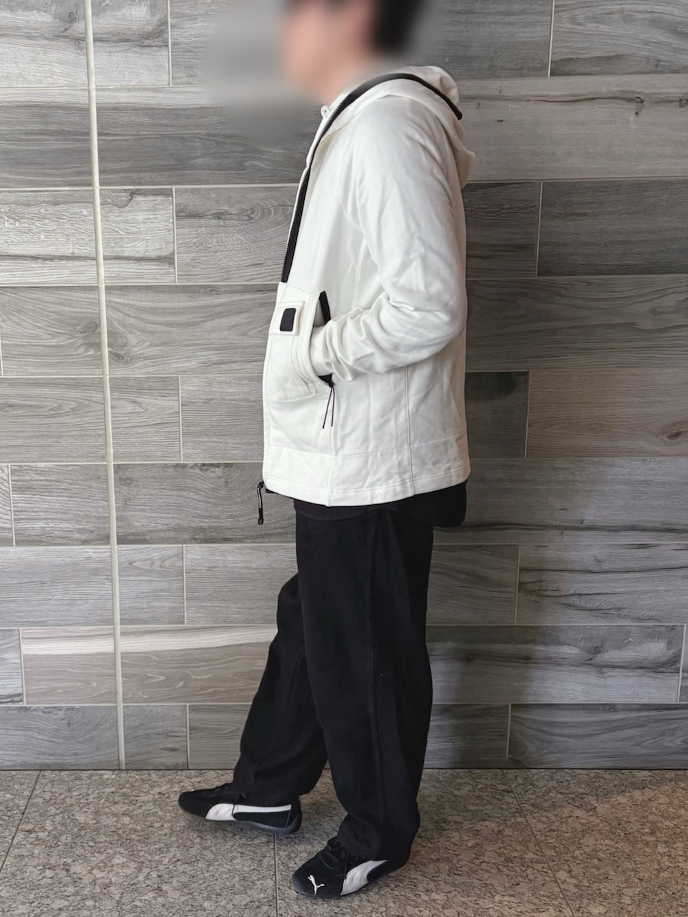 ホワイト系のパーカー、ブラック系のTシャツ/カットソー、ブラック系のデニムパンツを着用したメンズの春コーディネートの2枚目の写真