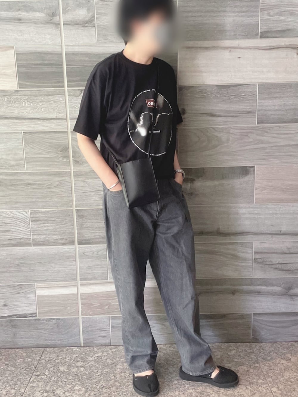 ブラック系のTシャツ/カットソー、グレー系のデニムパンツ、ブラック系のサンダルを着用したメンズの夏コーディネートの2枚目の写真