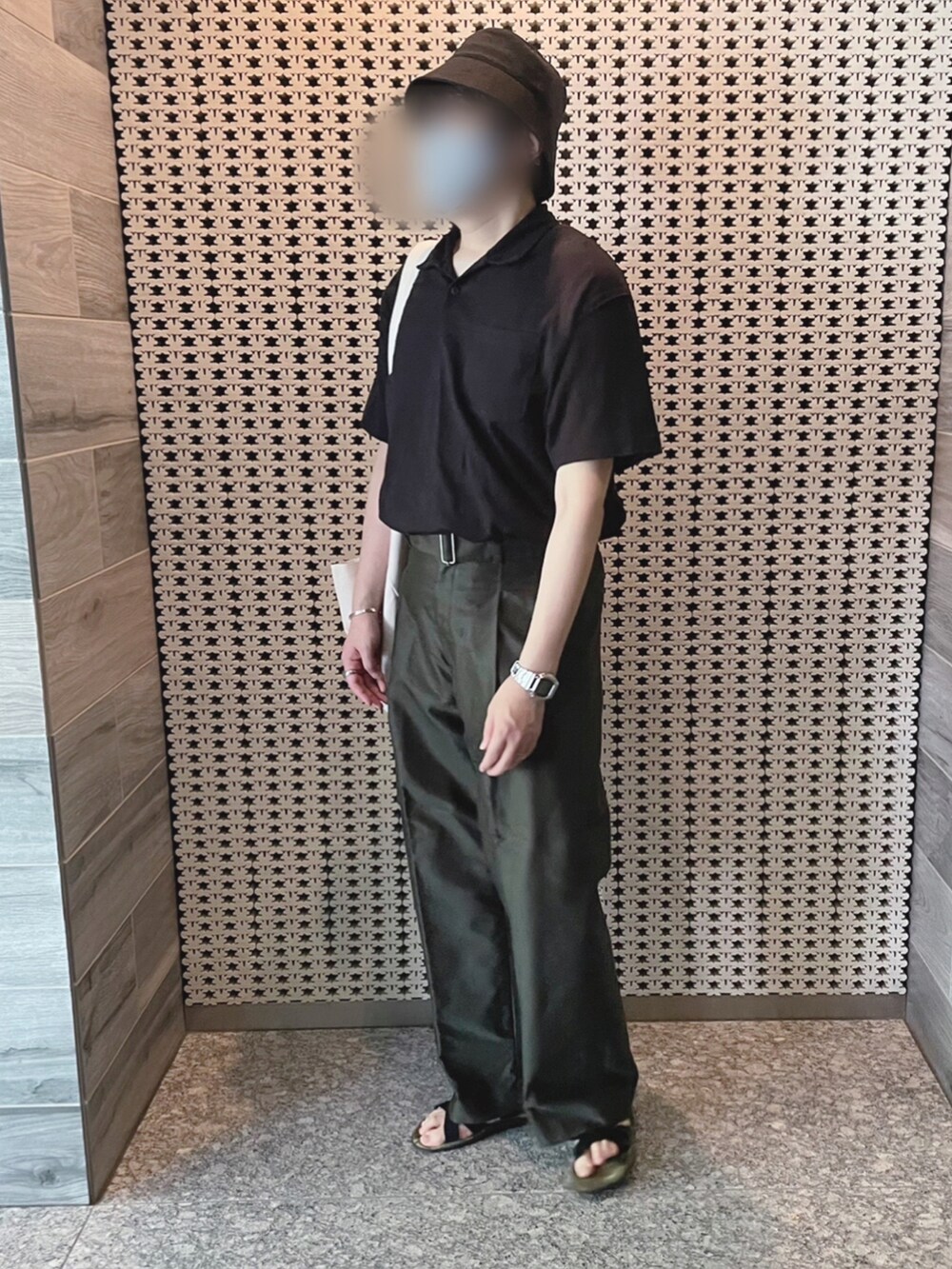 ブラック系のポロシャツ、グリーン系のその他パンツ、ホワイト系のトートバッグを着用したメンズの夏コーディネートの3枚目の写真