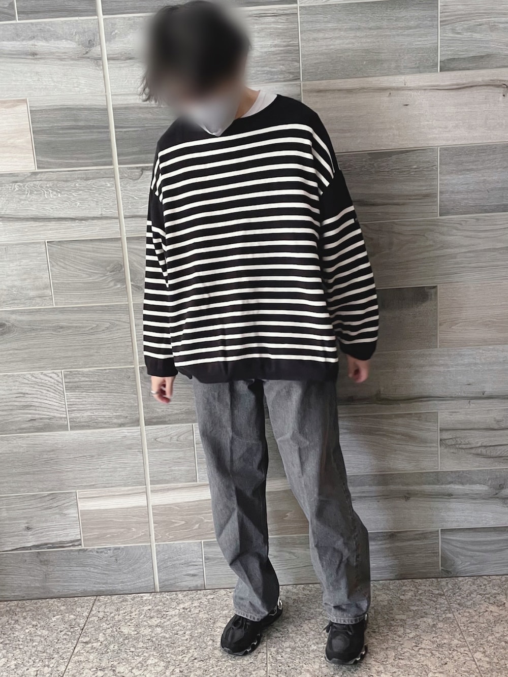 ブラック系のTシャツ/カットソー、グレー系のデニムパンツ、ブラック系のスニーカーを着用したメンズの秋コーディネートの3枚目の写真