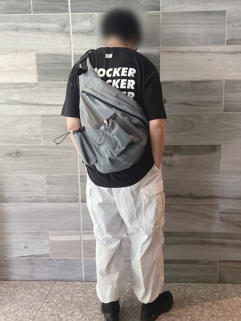 ブラック系のTシャツ/カットソー、ホワイト系のカーゴパンツ、ブラック系のブーツを着用したメンズの夏コーディネートの2枚目の写真