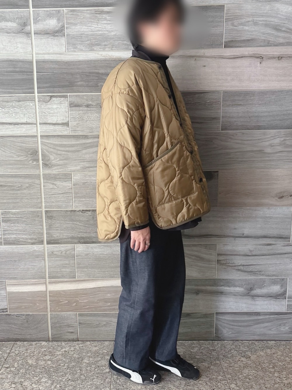 グリーン系のミリタリージャケット、ブラック系のシャツ/ブラウス、ブラック系のニット/セーターを着用したメンズの春コーディネートの2枚目の写真