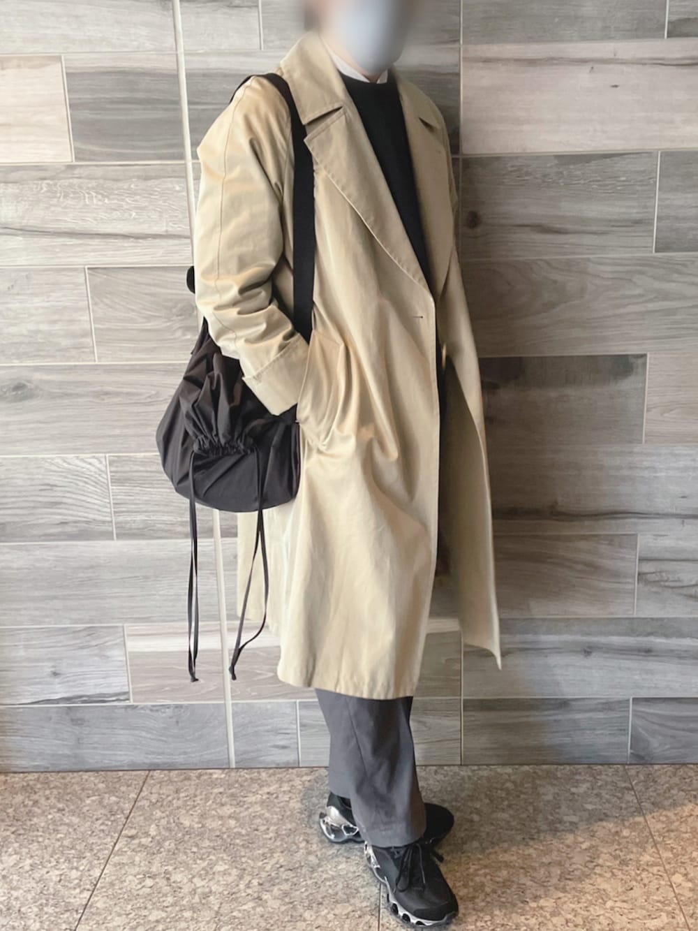 ベージュ系のトレンチコート、ブラック系のスウェット、グレー系のパンツを着用したメンズの冬コーディネートの3枚目の写真