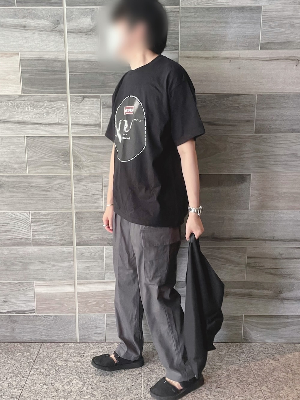 ブラック系のTシャツ/カットソー、グレー系のパンツ、ブラック系のトートバッグを着用したメンズの秋コーディネートの2枚目の写真