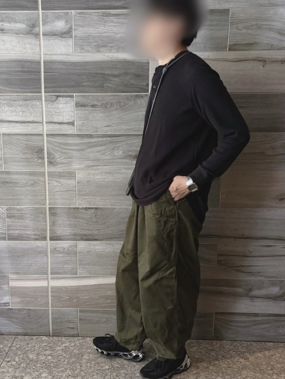 ブラック系のTシャツ/カットソー、グリーン系のパンツ、ブラック系のスニーカーを着用したメンズの秋コーディネートの2枚目の写真