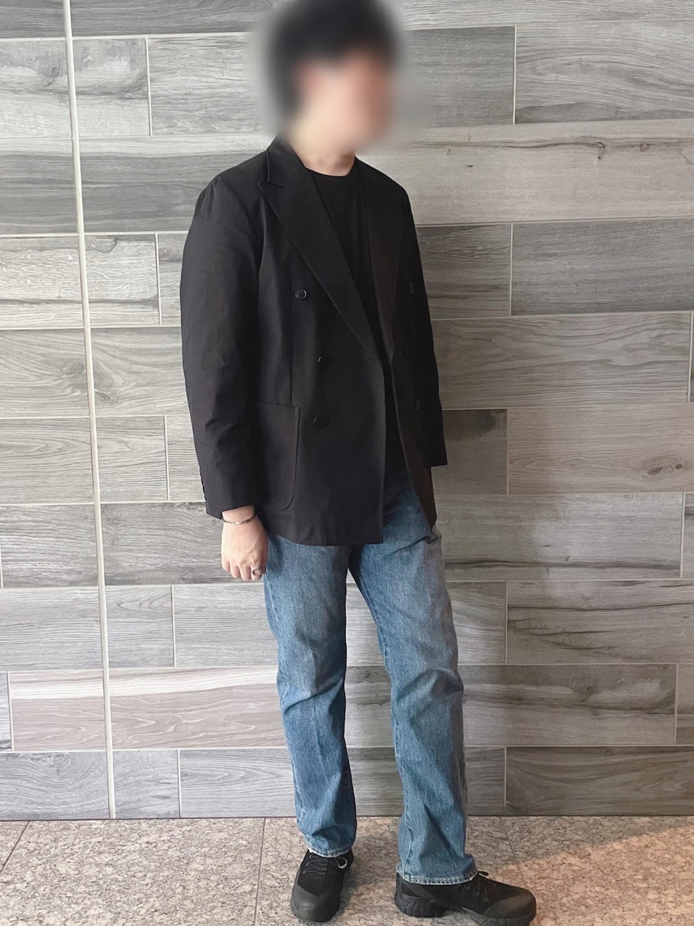 ブラック系のテーラードジャケット、ブルー系のデニムパンツ、ブラック系のブーツを着用したメンズの秋コーディネートの3枚目の写真