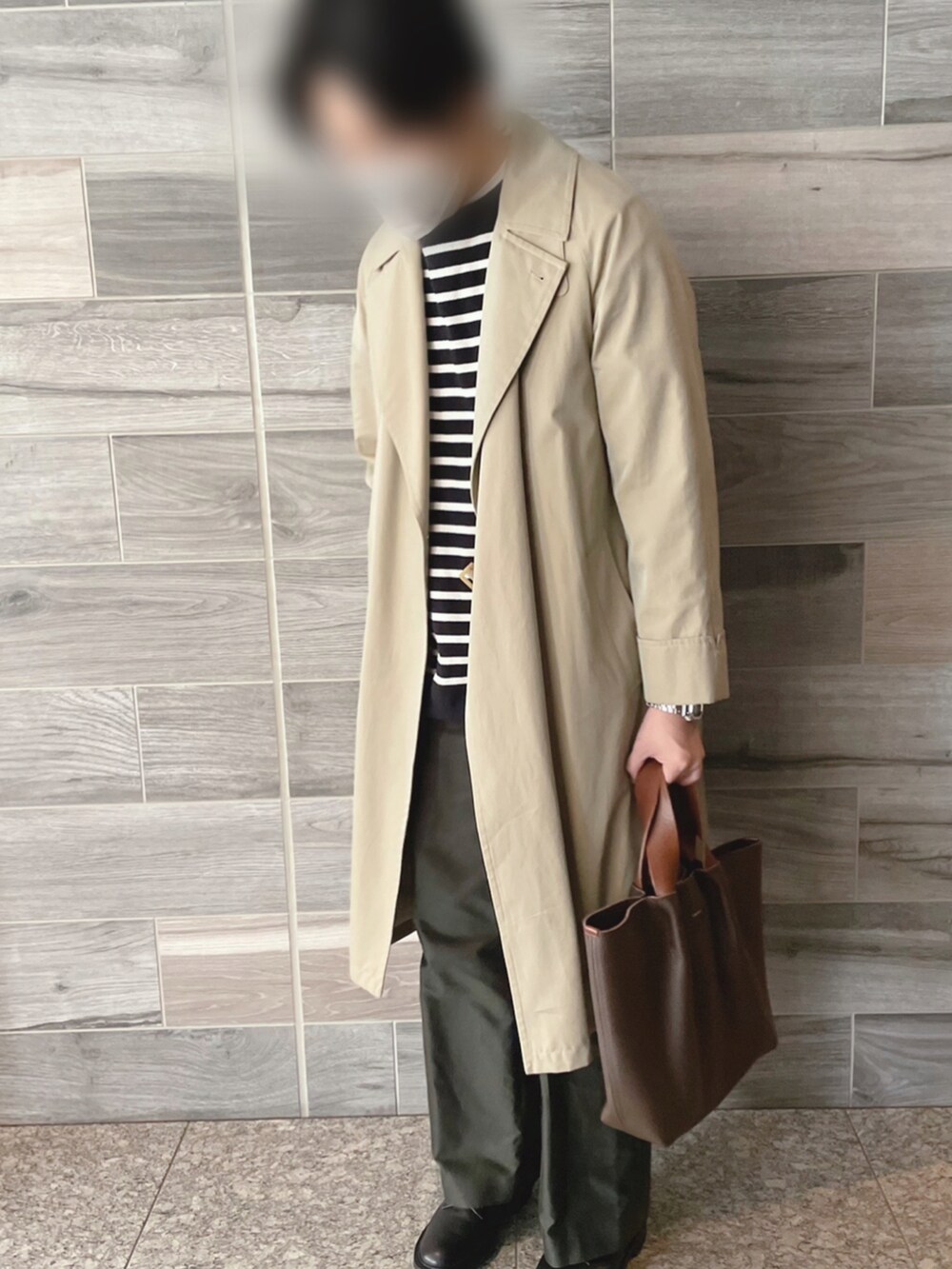 ベージュ系のトレンチコート、ブラック系のTシャツ/カットソー、グリーン系のその他パンツを着用したメンズの冬コーディネートの2枚目の写真