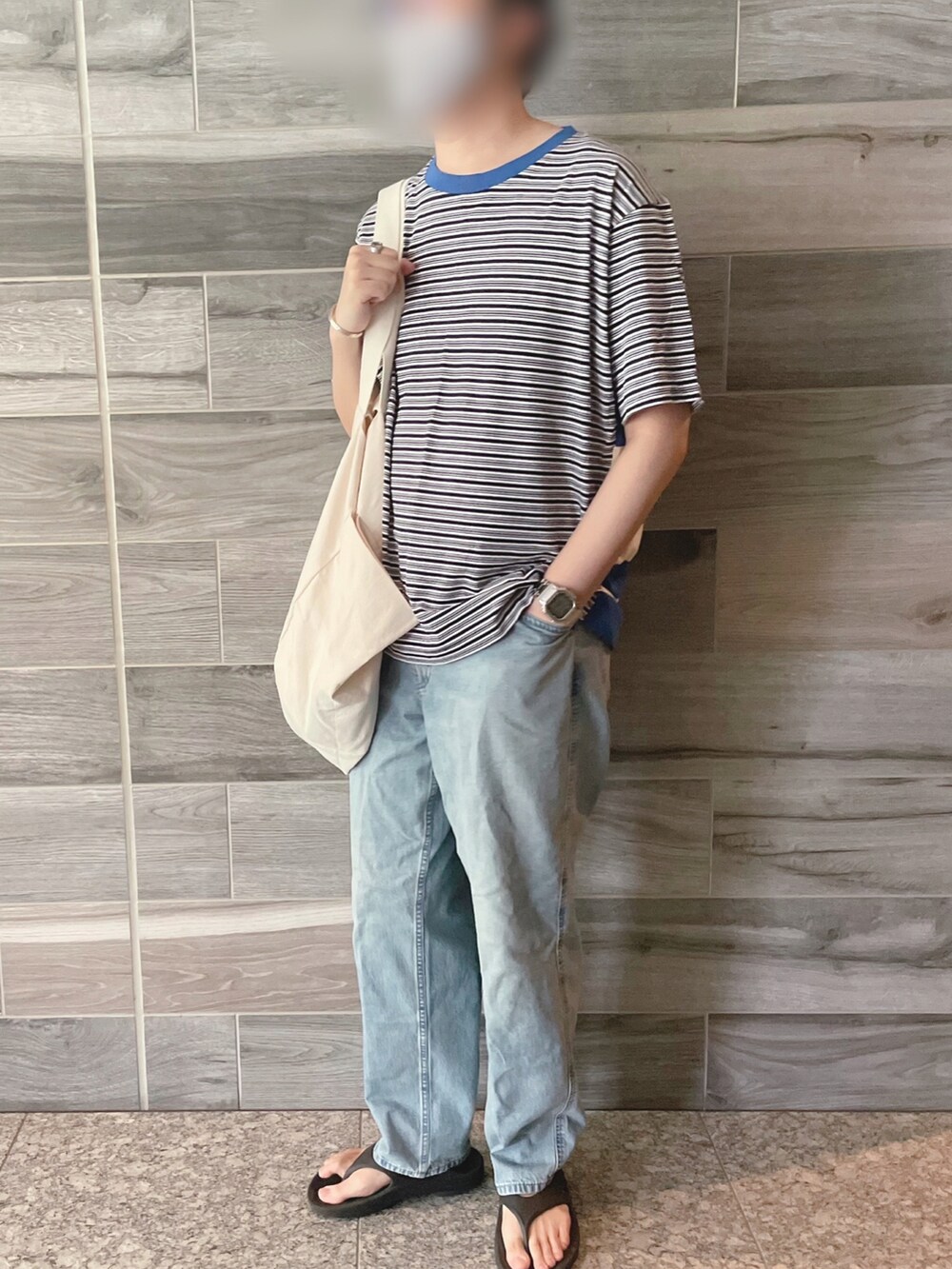 ブルー系のTシャツ/カットソー、ブルー系のデニムパンツ、ブラック系のサンダルを着用したメンズの秋コーディネートの3枚目の写真