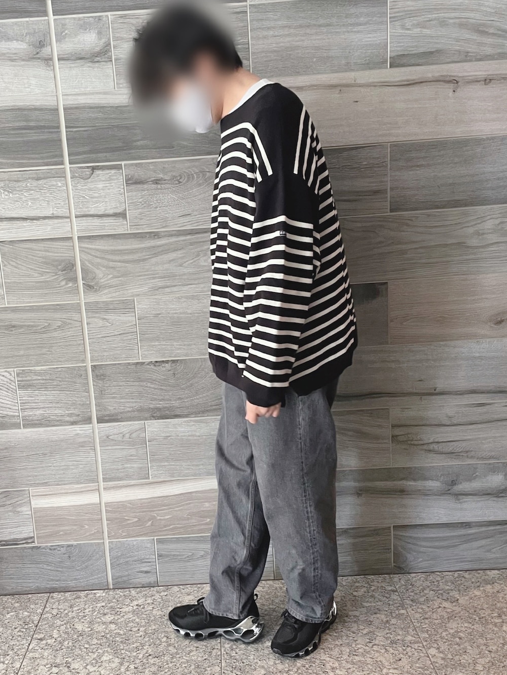 ブラック系のTシャツ/カットソー、グレー系のデニムパンツ、ブラック系のスニーカーを着用したメンズの秋コーディネートの2枚目の写真
