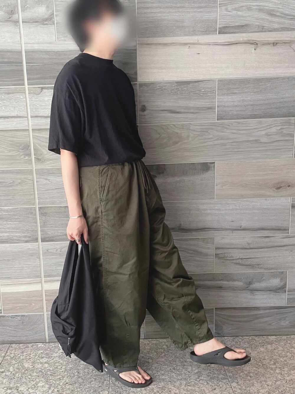 ブラック系のTシャツ/カットソー、グリーン系のパンツ、ブラック系のトートバッグを着用したメンズの秋コーディネートの2枚目の写真