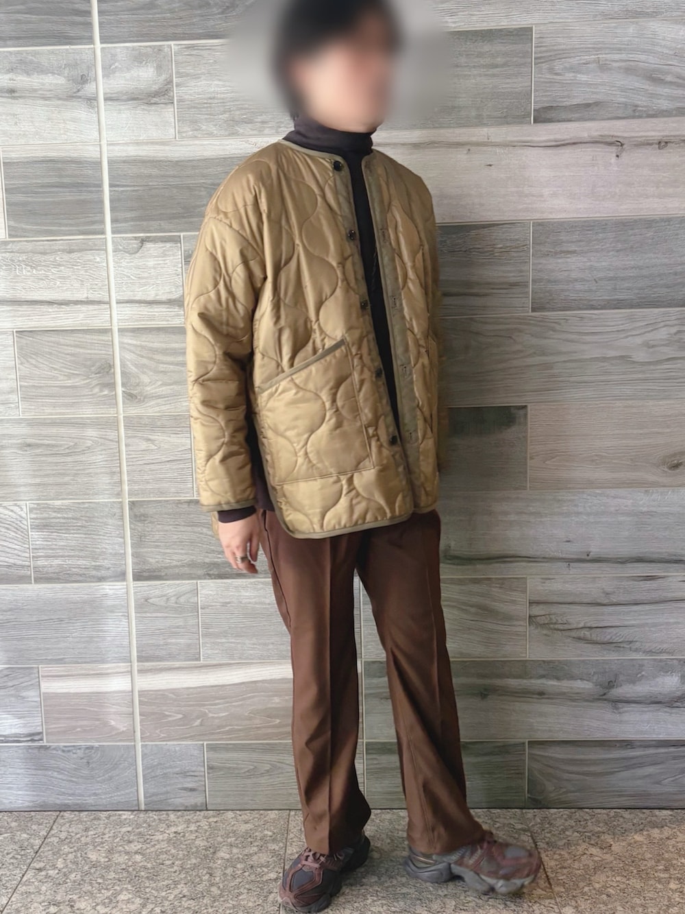 グリーン系のミリタリージャケット、ブラウン系のスウェット、ブラウン系のスラックスを着用したメンズの春コーディネートの3枚目の写真