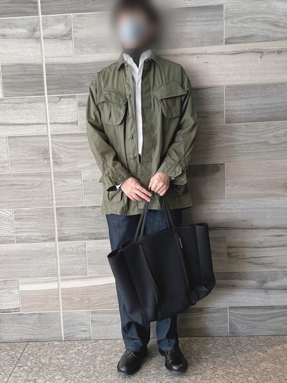 グリーン系のミリタリージャケット、ホワイト系のシャツ/ブラウス、ブラック系のニット/セーターを着用したメンズの春コーディネートの3枚目の写真