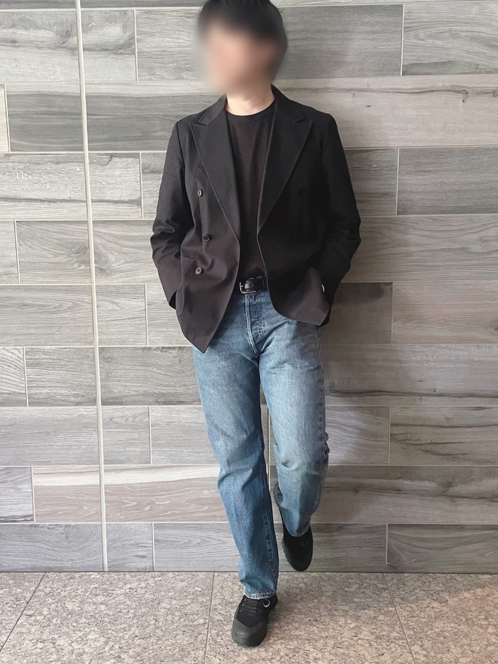 ブラック系のテーラードジャケット、ブルー系のデニムパンツ、ブラック系のブーツを着用したメンズの秋コーディネートの2枚目の写真